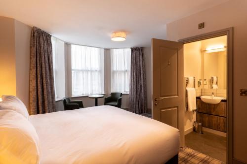a hotel room with a bed and a bathroom at Offshore - The Inn Collection Group in Lytham St Annes