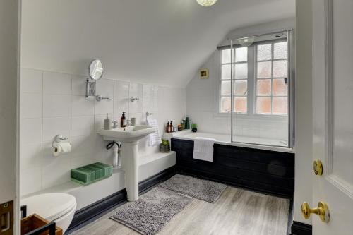 a white bathroom with a sink and a shower at Spacious, Luxurious Cliffes in Leicester