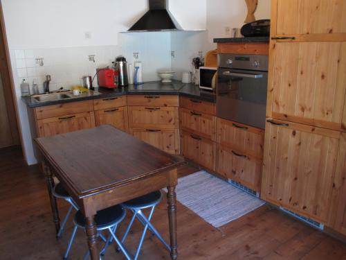a kitchen with wooden cabinets and a wooden table at Mayen de Planraveire in Orsières