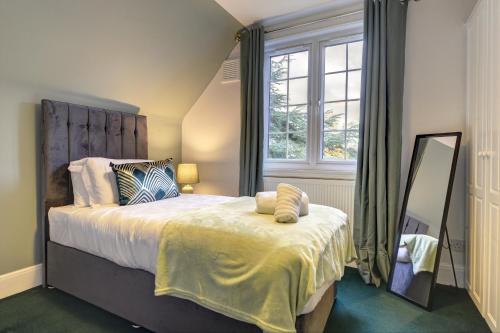 a bedroom with a large bed and a mirror at Spacious, Luxurious Cliffes in Leicester