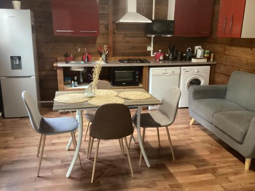 a kitchen with a table and chairs and a couch at Kaz Passion in Sainte-Marie