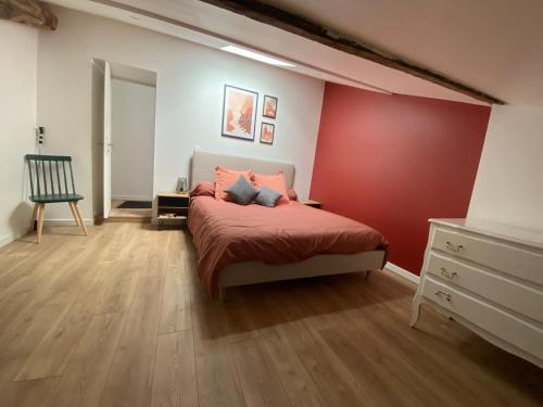 une chambre avec un lit et un mur rouge dans l'établissement Appartement chaleureux 6 pers, à Beychac-et-Caillau