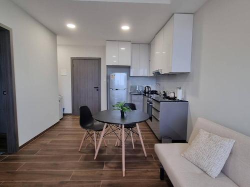 a kitchen with a table and chairs in a room at Hermoso departamento Curupaú Isuto in Santa Cruz de la Sierra