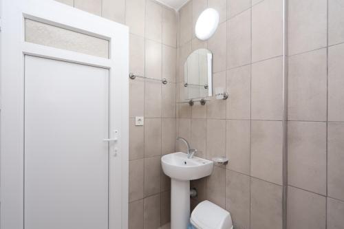 een badkamer met een wastafel, een toilet en een spiegel bij Blue Life Hotel in Konak