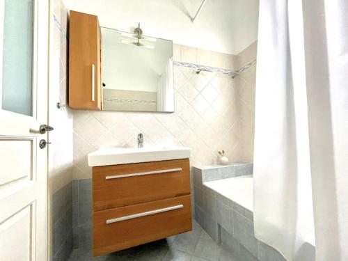 a bathroom with a sink and a mirror and a tub at Erietta's Home in Andiparos