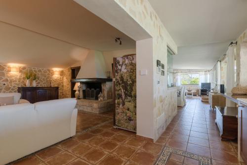 un soggiorno con divano bianco e camino di Villa Enò by Perle di Puglia a Noci