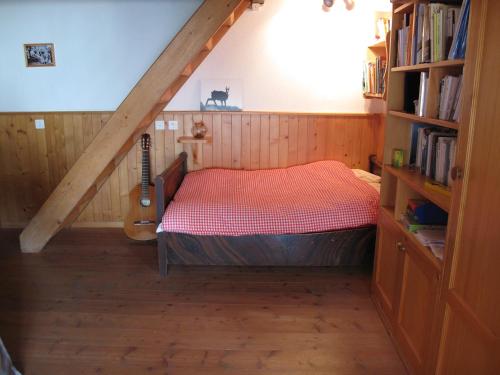 a bedroom with a bed and a guitar in a attic at Mayen de Planraveire in Orsières