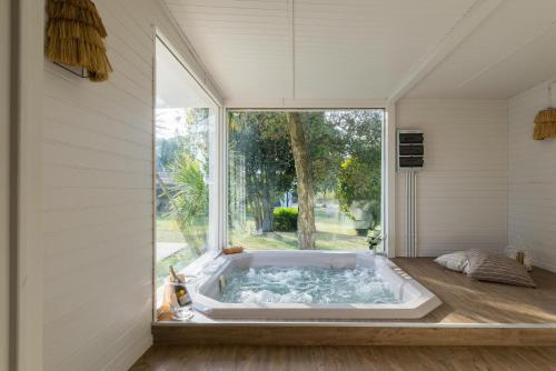 a jacuzzi tub in a room with a window at Villa Enò by Perle di Puglia in Noci