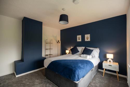 a bedroom with blue walls and a large bed at Renvyle House By Horizon Stays in Stockton-on-Tees