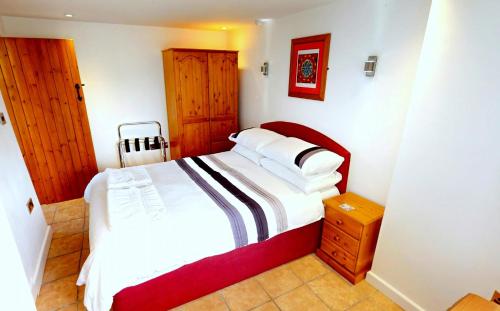 ein Schlafzimmer mit einem Bett mit weißen Laken und Kissen in der Unterkunft CROYDE WONKY COTTAGE 1 Bedroom in Croyde