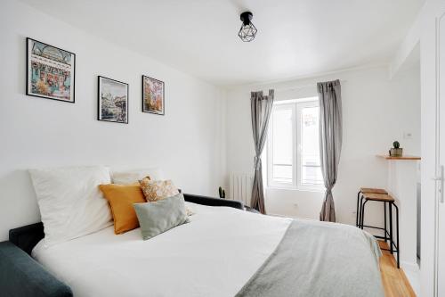 een slaapkamer met een wit bed en een raam bij Cute studio in Bastille- Bail mobilité in Parijs