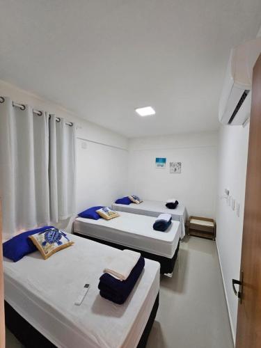 a room with three beds in a hospital room at Ap barra grande com piscina in Marau