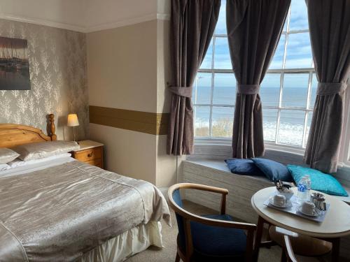 a bedroom with a bed and a table and a window at The Whiteley in Scarborough