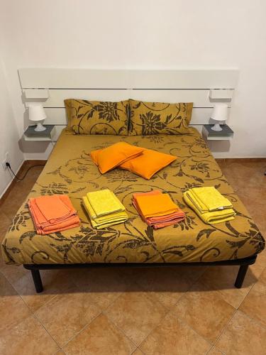 Una cama con cuatro almohadas y libros. en Apartment De Rosa, en Pero