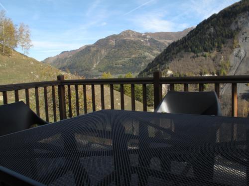 a table on a balcony with a view of mountains at Mayen de Planraveire in Orsières