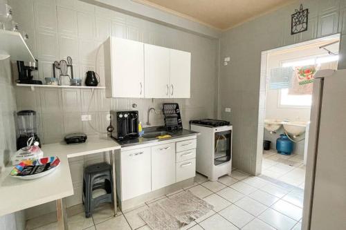 a kitchen with white cabinets and a stove top oven at 3 Quartos da UFU in Uberlândia
