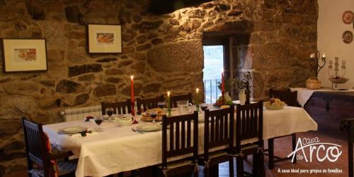 a dining room with a table in a stone wall at Casa do Arco - Casa de Campo in Mezio