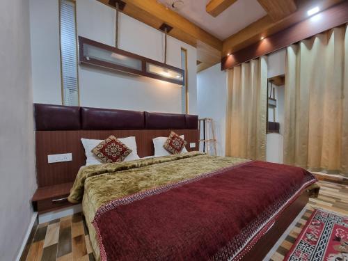 een slaapkamer met een groot bed en een rode deken bij Green View By Wow Hotels in Banikhet