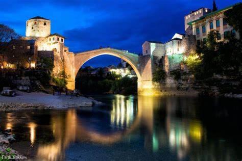 eine Brücke über einen Fluss in einer Stadt nachts in der Unterkunft Villa Esra Mostar in Mostar