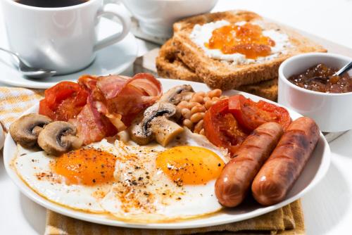a plate of breakfast food with eggs sausage and toast at Holiday Inn Haydock by IHG in Haydock