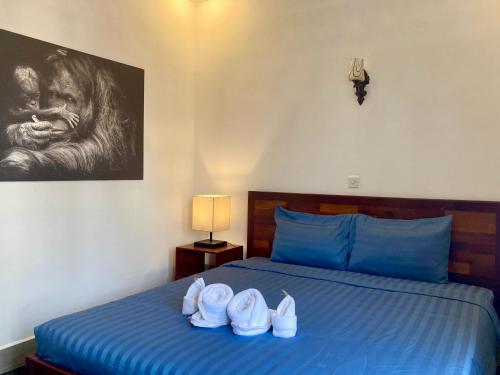 a bedroom with a blue bed with shoes on it at Lotus Haven Villa in Siem Reap