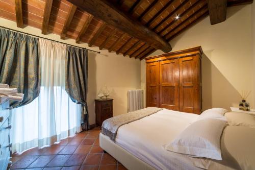 una camera con un letto e una grande finestra di Relais La Costa Historical Residence a Monteriggioni