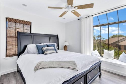 a bedroom with a large bed with a ceiling fan at Modern Designed, Lakefront Home in Garland in Garland