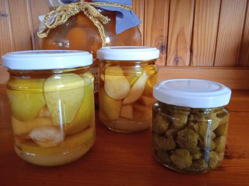 três frascos de pickles e nozes numa mesa em Locanda dell'Amicizia em Seccheto