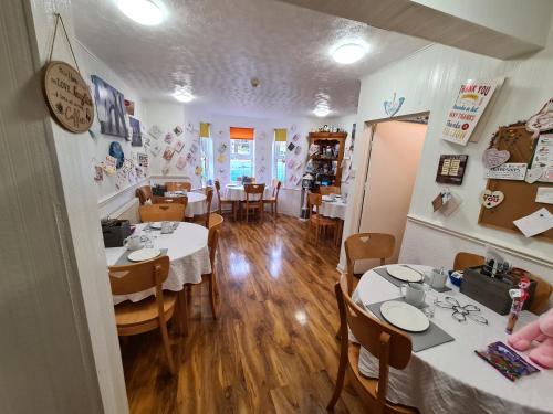 a dining room with tables and chairs in a restaurant at Beachdene Guest House in Skegness