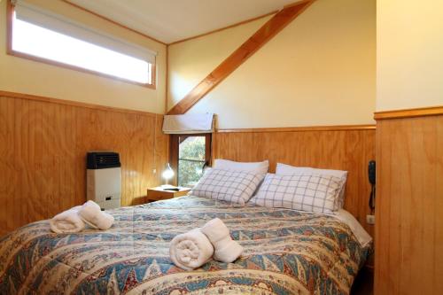 a bedroom with a bed with towels on it at Apart Hotel Villa Los Ciruelos in Valdivia