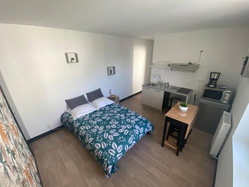 a small bedroom with a bed and a kitchen at Appartement proche centre & gare in Niort