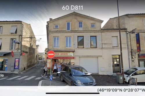 a car parked in front of a building with a stop sign at Appartement proche centre & gare in Niort