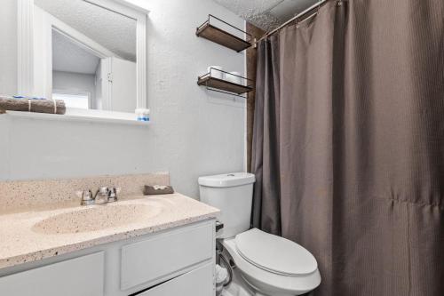 ダラスにあるExtended Stay in DFW One Bedroom Apartmentのトイレ、洗面台、鏡のあるバスルーム