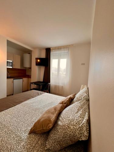 um quarto com uma cama e uma janela em Studio 2 pers face gare SNCF Appart Hotel le Cygne D2 em Bourges