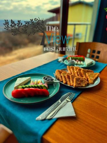 una mesa con platos de comida sobre un mantel azul en Парк хотел Боили-Кирека, en Kaspichan