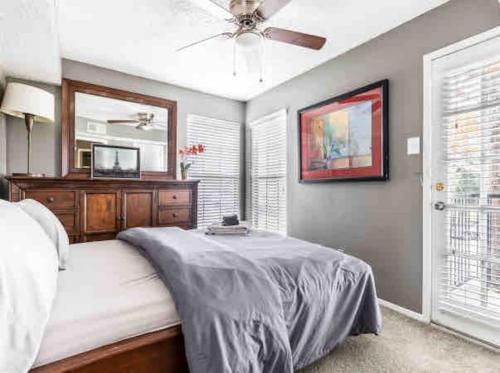 a bedroom with a bed and a ceiling fan at Affordable Apartment with Balcony in Dallas
