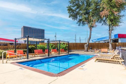 a swimming pool with orange lounge chairs at Cozy North Dallas One Bedroom Stay in Dallas