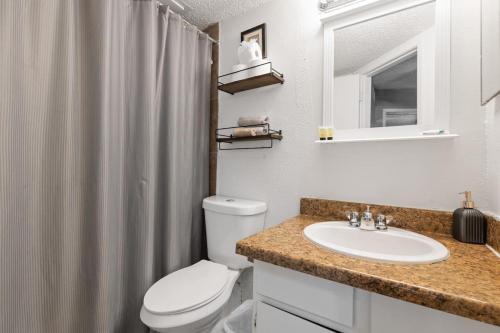 a bathroom with a white toilet and a sink at Cozy Corporate Unit in DFW in Dallas