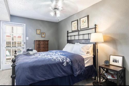 a bedroom with a bed with a blue comforter at Cozy Corporate Unit in DFW in Dallas