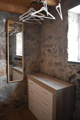 uma casa de banho com um espelho e uma cómoda em madeira em Casa de Celebrar a Vida em Monchique