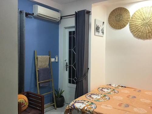 een slaapkamer met een bed en een blauwe muur bij Kitya Homestay in Phumĭ Ta Phŭl