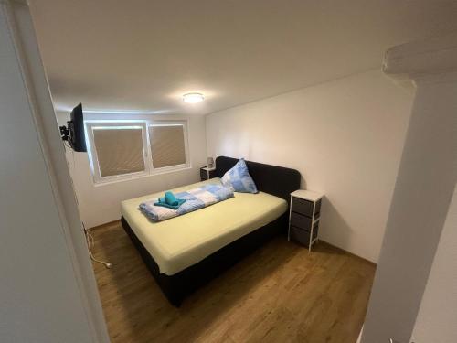 niewielka sypialnia z łóżkiem z niebieskimi poduszkami w obiekcie Auszeit am See w mieście Dahmen
