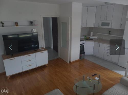 un salon vide avec une télévision et une cuisine dans l'établissement Apartman KoprenaZ, à Banja Luka