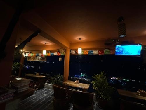 a room with a bar with plants and a television at Nar-Bis Hotel in Pokhara