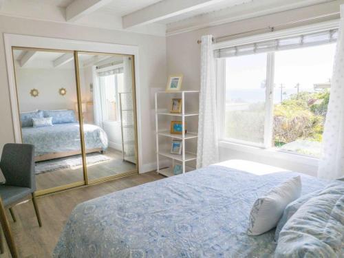 a bedroom with a bed and a large window at STUNNINGLY PERFECT Beach ALL NEW REMODEL Galore in Laguna Beach