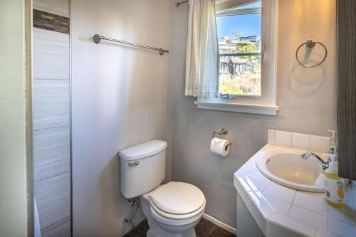 a bathroom with a toilet and a sink and a window at MAGICAL COTTAGE DIRECT OCEAN VIEW BEACH W GARAGE, YARD, FIREPLACE in Laguna Beach