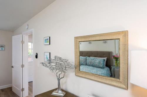a mirror on a wall with a bed in a room at 100 PERCENT NEW STUNNING HUGE HOME, GARDEN BEACH, RESERVED Parking in Laguna Beach