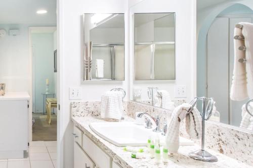 La salle de bains blanche est pourvue d'un lavabo et d'un miroir. dans l'établissement Glamorous Regal Design Home with Private Patio and Garage, à Laguna Hills