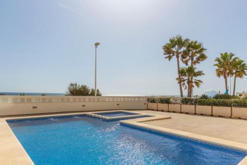 a swimming pool in a house with palm trees at Apartamento Bernia al Mar 8A by Costa CarpeDiem in Calpe