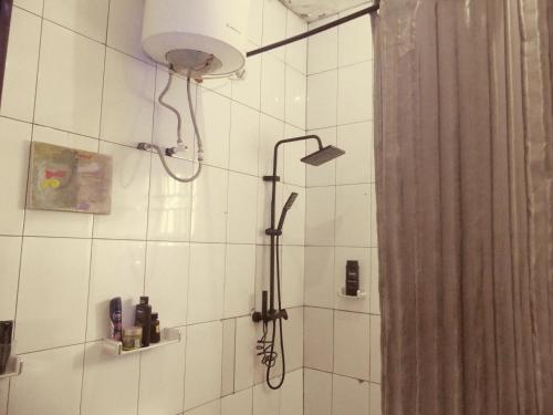 La salle de bains est pourvue d'une douche avec un pommeau de douche. dans l'établissement Templar's Court, à Port Harcourt